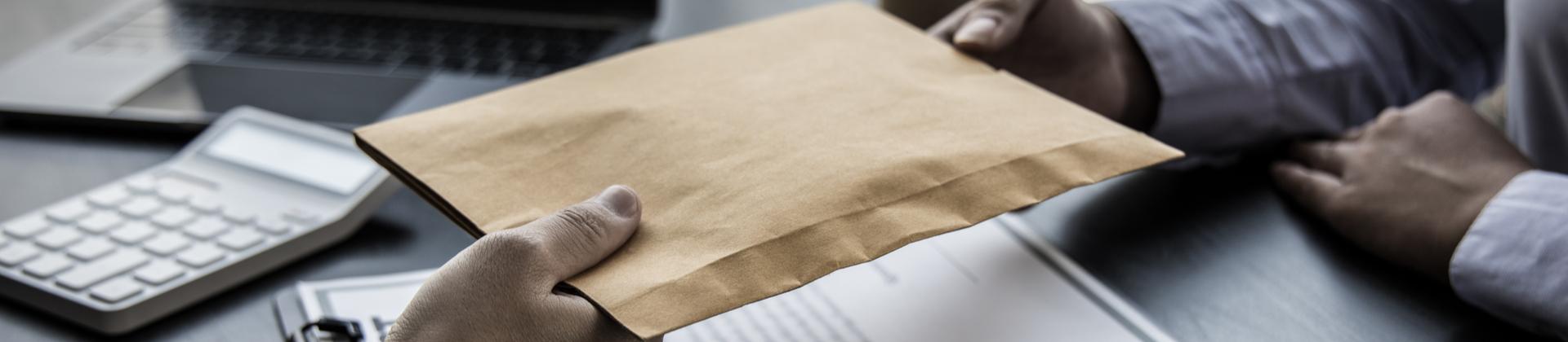 Office workers exchanging envelope 