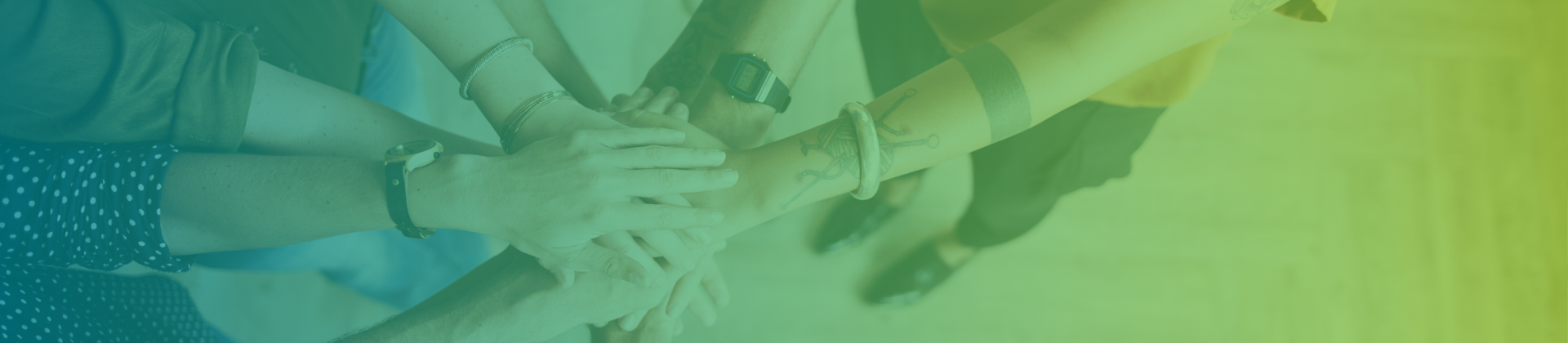 A group of diverse hands joined together in a circle, symbolizing teamwork and unity.