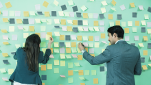 people hanging up sticky notes